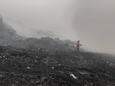 Petugas damkar menyiramkan air di TPA Rawa Kucing. Foto: kumparan