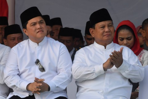 Menteri Pertahanan Prabowo Subianto (kanan) dan Menteri BUMN Erick Thohir (kiri) menyimak pidato Presiden Joko Widodo saat apel Hari Santri Nasional di Tugu Pahlawan, Surabaya, Jawa Timur, Minggu (22/10/2023). Foto: Zabur Karuru/Antara Foto