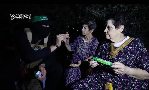 Pejuang Hamas memberi biskuit kepada wanita Israel yang menjadi tawanan. Hamas membebaskan dua tawanan itu pada Senin, 23 Oktober 2023. Foto: Twitter/@QudsNen