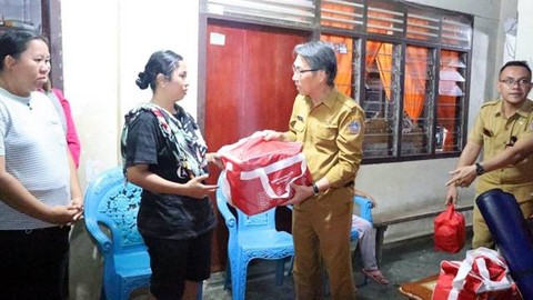 Penjabat Bupati Sitaro, Joi Eltiano B Oroh, saat menyerahkan bantuan kepada korban bencana kebakaran