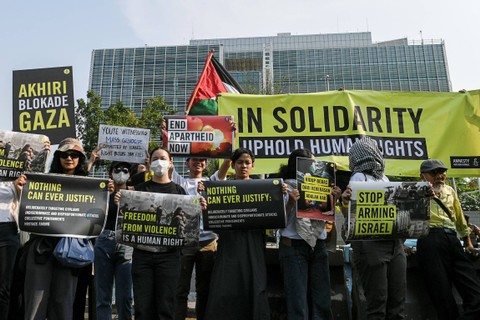 Sejumlah pegiat HAM dari Amnesty International Indonesia membentangkan tulisan dan poster saat melakukan aksi di depan Kedutaan Besar Amerika Serikat untuk Indonesia, Jakarta, Jumat (27/10/2023). Foto: Hafidz Mubarak A/ANTARA FOTO