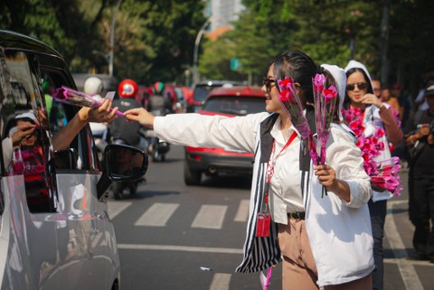 Massa dari relawan Ganjar Pranowo membagikan bunga mawar di kawasan Menteng, Jakarta, Sabtu (28/10/2023). Foto: Iqbal Firdaus/kumparan