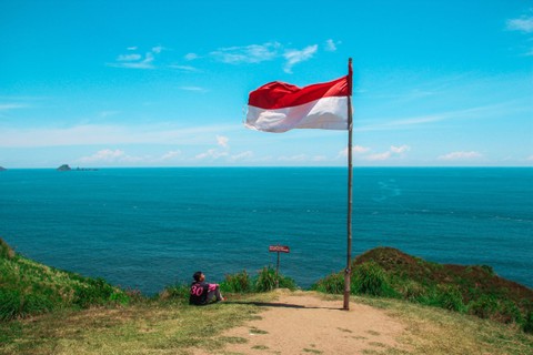 Pemudan dan Bendera Merah Putih. Foto: Unspalsh