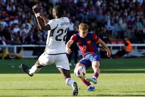 Pemain FC Barcelona Fermin Lopez beraksi bersama pemain Real Madrid Antonio Rudiger di Stadion Olimpic Lluis Companys, Barcelona, Spanyol, Sabtu (28/10/2023). Foto: Albert Gea/REUTERS