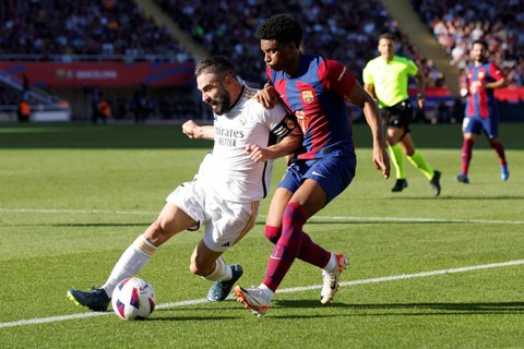 Pemain Real Madrid Dani Carvajal beraksi bersama pemain FC Barcelona Alejandro Balde di Stadion Olimpic Lluis Companys, Barcelona, Spanyol, Sabtu (28/10/2023). Foto: Albert Gea/REUTERS