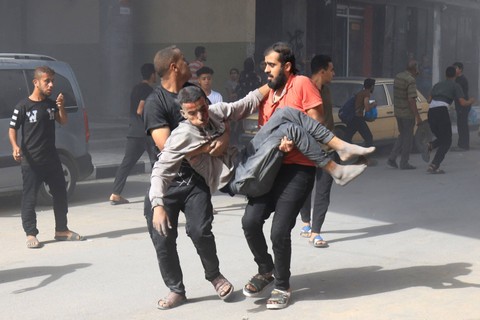 Warga Palestina membawa korban selamat setelah pemboman Israel, di Khan Yunis di Jalur Gaza selatan pada 26 Oktober 2023. Foto: Mahmud Hams/AFP