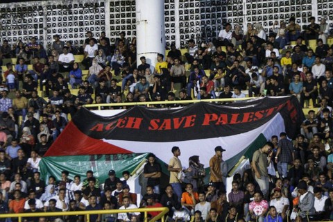 Penonton mengibarkan bendera Palestina saat pertandingan Persiraja vs Semen Padang FC di Stadion Harapan Bangsa Banda Aceh, Sabtu malam (21/10/2023). Foto: KBA.ONE