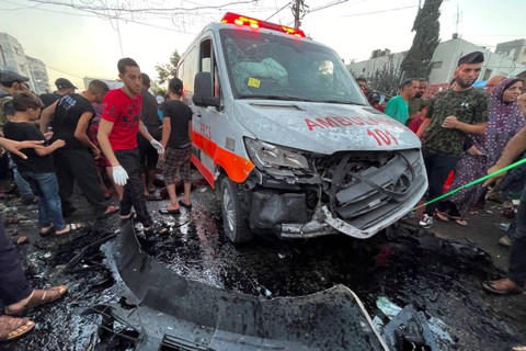 Warga Palestina memeriksa kerusakan setelah konvoi ambulans dihantam serangan Israel, di pintu masuk rumah sakit Shifa di Kota Gaza, Jumat (3/11/2023). Foto: Mohammed Al-Masri/REUTERS