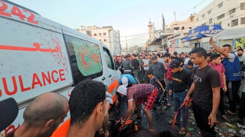 Warga Palestina mengeluarkan seekor kuda yang mati saat mereka memeriksa kerusakan pada ambulans setelah konvoi ambulans dihantam, di pintu masuk rumah sakit Shifa di Kota Gaza, Jumat (3/11/2023). Foto: Mohammed Al-Masri/REUTERS