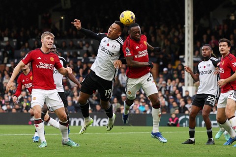 Pemain Manchester United Aaron Wan-Bissaka beraksi dengan pemain Fulham Rodrigo Muniz di Craven Cottage, London, Inggris, Sabtu (4/11/2023). Foto: Hannah McKay/REUTERS