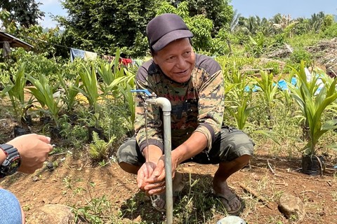 Salah satu warga bernama Pesawat sedang mengambil air di keran depan rumahnya yang mengalir dari pipa yang dibangun JOB Pertamina & Medco E&P Tomori di Dusun Tombiobong, Desa Maleo Jaya, Kabupaten Banggai, Provinsi Sulawesi Selatan, Rabu (1/11/2023). Foto: Ema Fitriyani/kumparan