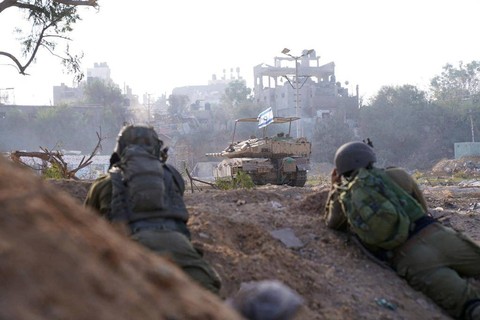 Tentara Israel bekerja di dekat kendaraan militer selama operasi darat, di tengah konflik yang sedang berlangsung antara Israel dan kelompok Islam Palestina Hamas, di lokasi yang disebut sebagai Gaza, Kamis (9/11/2023). Foto: Pasukan Pertahanan Israel/Handout via REUTERS