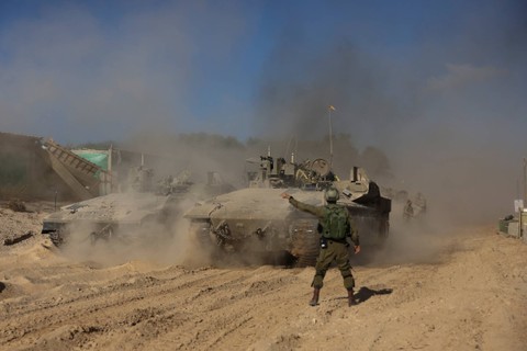 Seorang tentara Israel memberi isyarat saat kendaraan militer bermanuver, di tengah invasi darat yang sedang berlangsung terhadap kelompok Islam Palestina Hamas di Jalur Gaza utara, Rabu (8/11/2023). Foto: Ronen Zvulun/REUTERS