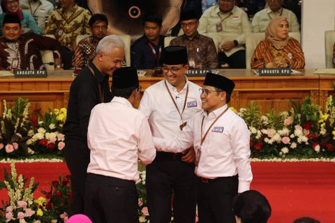 Pasangan calon presiden dan wakil presiden Ganjar Pranowo-Mahfud MD berjabat tangan dengan pasangan Anies Baswedan-Cak Imin dalam acara pengundian nomor urut ketiga pasangan capres-cawapres di KPU RI, Jakarta, Selasa (14/11/2023). Foto: Aditia Noviansyah/kumparan