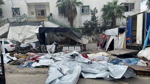 Jenazah warga Palestina yang tewas dalam serangan Israel tergeletak di halaman rumah sakit Al Shifa, di Kota Gaza, Minggu (12/11/2023). Foto: Ahmed El Mokhallalati/via REUTERS 