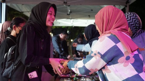 Pengunjung mengantre untuk mendapatkan songgo buwono dan roti kembang waru dalam acara Selasa Wagen di Malioboro pada Selasa (14/11) malam. Foto: Arif UT/Pandangan Jogja