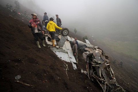 Warga berada di dekat bangkai pesawat tempur taktis EMB-314 Super Tucano TNI AU yang mengalami kecelakaan di Pasuruan, Jawa Timur, Jumat (17/11/2023). Foto: Umarul Faruq/Antara Foto