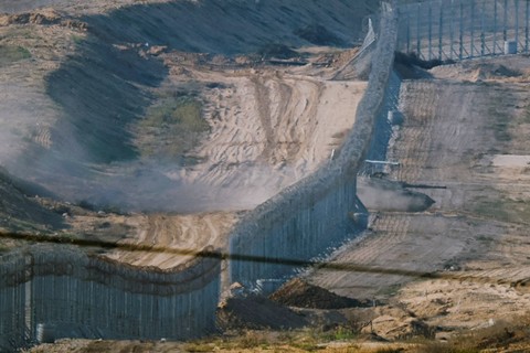 Sebuah tank bermanuver melalui pagar perbatasan Jalur Gaza dengan Israel, Jumat (17/11/2023). Foto: Alexander Ermochenko/REUTERS