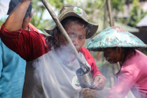 Ketua Kelompok Wanita Tani (KWT) Tampelas Raya, Theti membuat alat pemanas tradisional untuk melubangi plastik moza yang dipasang pada tanah bekas gambut di lahan percontohan (Demplot) di Desa Mantangai Hilir, Kapuas, Kalimantan Tengah. Foto: Makna Zaezar/ANTARA FOTO