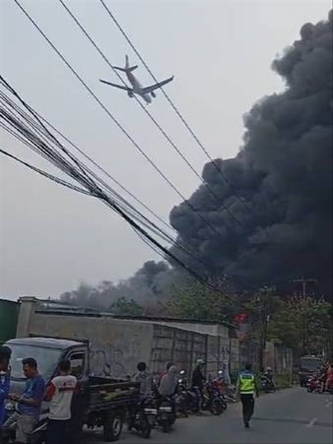 Pesawat melewati kepulan asap kebakaran pabrik sendal di Tangerang. Foto: Dok. Istimewa
