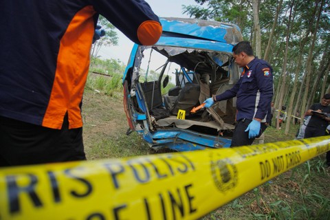 Petugas Ditreskrim Polda Jatim melakukan olah TKP kecelakaan mini bus yang tertabrak kereta api (KA) Probowangi di Kecamatan Klakah, Lumajang, Jawa Timur, Senin (20/11/2023). Foto: Irfan Sumanjaya/ANTARA FOTO