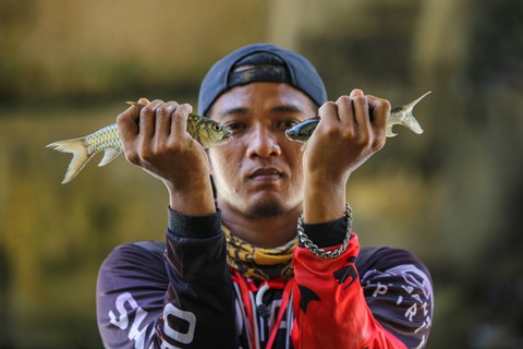 Warga menunjukan ikan Jurung hasil pancingan dalam acara Lubuk Larangan di Kabupaten Tapanuli Selatan, provinsi Sumatera Utara, Sabtu (18/11). Foto: Aditia Noviansyah/kumparan