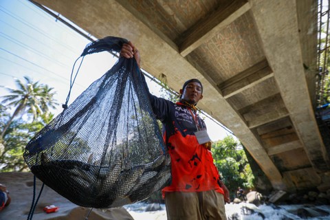 Warga menunjukan ikan Jurung hasil pancingan dalam acara Lubuk Larangan di Kabupaten Tapanuli Selatan, provinsi Sumatera Utara, Sabtu (18/11). Foto: Aditia Noviansyah/kumparan
