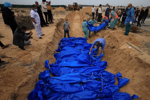 Warga Palestina menguburkan jenazah di kuburan massal di pemakaman Khan Yunis, di Jalur Gaza selatan pada Rabu (22/11/2023). Foto: Mahmud Hams/AFP