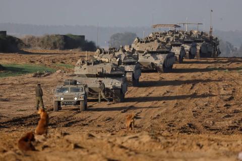 Konvoi tank militer Israel dan Pengangkut Personil Lapis Baja (APC) melewati perbatasan Israel, usai meninggalkan Gaza selama gencatan senjata, di Israel, Jumat (24/11/2023). Foto: Amir Cohen/REUTERS