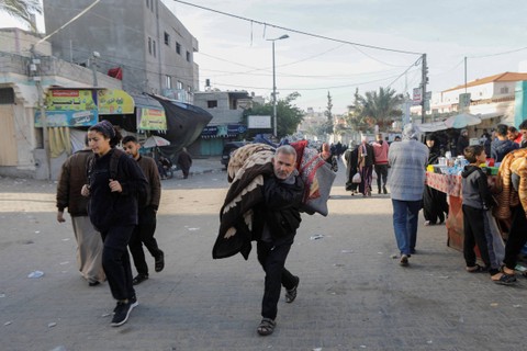 Warga Palestina kembali ke rumah mereka, selama gencatan senjata sementara antara Hamas dan Israel, di Khan Younis di selatan Jalur Gaza, Jumat (24/11/2023). Foto: Ibraheem Abu Mustafa/REUTERS