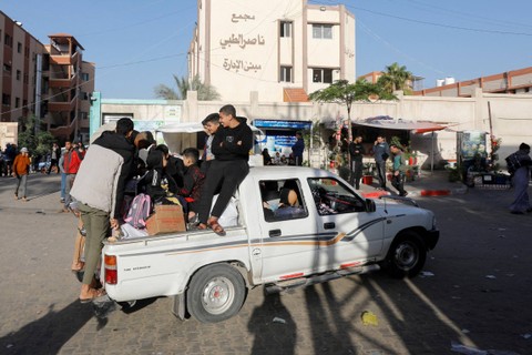 Warga Palestina duduk di dalam kendaraan saat mereka hendak pulang, selama gencatan senjata sementara antara Hamas dan Israel, di Khan Younis di selatan Jalur Gaza, Jumat (24/11/2023). Foto: Saleh Salem/REUTERS
