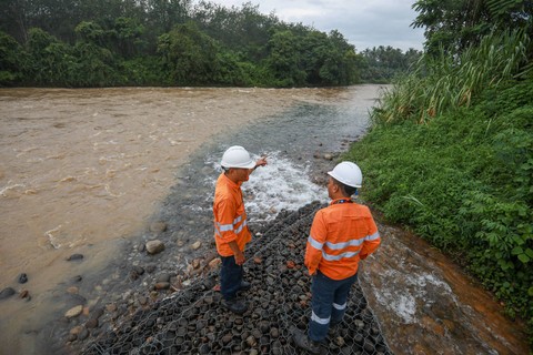Petugas memeriksa aliran air sisa proses penambangan emas Martabe yang dialirkan ke Sungai Batangtoru, Tapanuli Selatan, Sumatera Utara, Sabtu (18/11). Foto: Aditia Noviansyah/kumparan