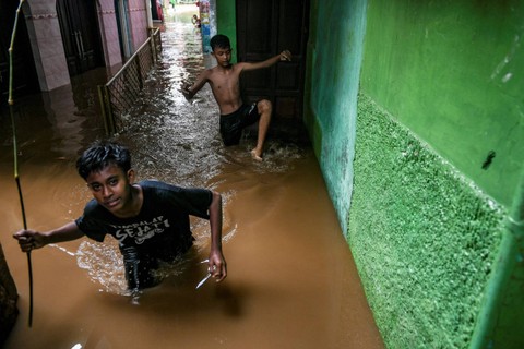 Warga melntasi banjir yang melanda di kawasan Kebon Pala, Kampung Melayu, Jakarta, Kamis (30/11/2023). Foto: Hafidz Mubarak A/ANTARA FOTO