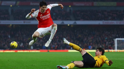 Takehiro Tomiyasu duel dengan Hugo Bueno saat Arsenal vs Wolverhampton Wanderers dalam laga pekan ke-14 Liga Inggris 2023/24 di Stadion Emirates, London, pada Sabtu (2/12/2023) malam WIB. Foto: REUTERS/Hannah Mckay