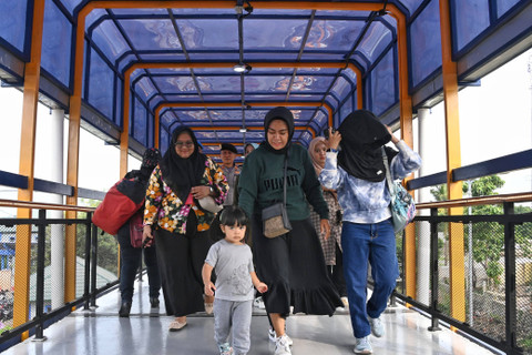 Warga menggunakan Jembatan Penyeberangan Layang yang menghubungkan Stasiun Kereta Rel Listrik (KRL) Bojonggede dengan Terminal Tipe C di Kabupaten Bogor, Sabtu (9/12). Foto: Dok: Kemenhub