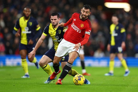 Pemain Pemain Manchester United Bruno Fernandes beraksi dengan pemain AFC Bournemouth Lewis Cook di Old Trafford, Manchester, Inggris, Sabtu (9/12/2023). Foto: Molly Darlington/REUTERS