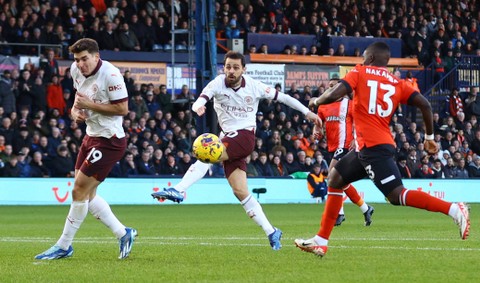 Pemain Manchester City Bernardo Silva menembak ke gawang Luton Town saat pertandingan di Kenilworth Road, Luton, Inggris. Foto: Matthew Childs/Reuters