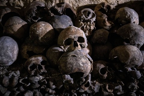 Tengkorak dan tulang manusia disejajarkan di dinding Katakombe Paris, bekas tambang kota tempat sisa-sisa sekitar enam juta orang dipindahkan dari kuburan Paris antara akhir abad ke-18 hingga 1861. Foto: Julien De Rosa / AFP