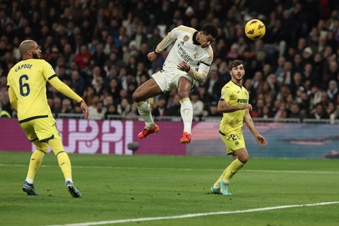 Jude Bellingham (tengah) mencetak gol pertama Real Madrid saat melawan Villarreal dalam pertandingan Liga Spanyol 2023/24 di Stadion Santiago Bernabeu, Senin (18/12). Foto: Thomas Coex/AFP
