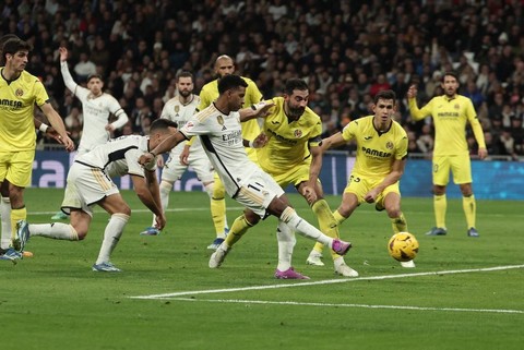 Rodrygo (tengah) mencetak gol kedua Real Madrid saat melawan Villarreal dalam pertandingan Liga Spanyol 2023/24 di Stadion Santiago Bernabeu, Senin (18/12). Foto: Thomas Coex/AFP