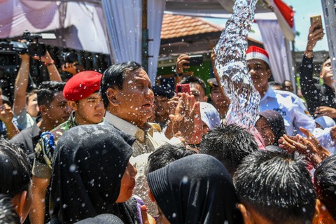 Menteri Pertahanan Prabowo Subianto bermain air bersama anak-anak saat kegiatan peresmian dan penyerahan proyek bantuan air bersih di Desa Pamupukan, Kabupaten Kuningan, Jawa Barat, Rabu (20/12/2023). Foto: Galih Pradipta/ANTARA FOTO