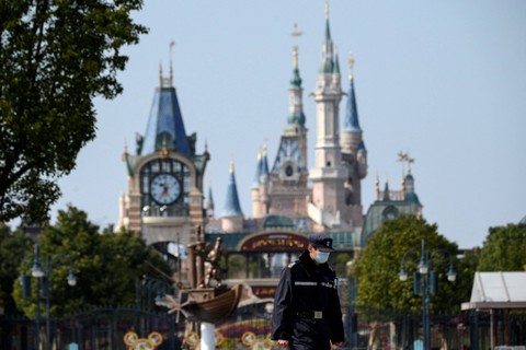 Seorang penjaga keamanan mengenakan masker pelindung terlihat di resor Disney Shanghai pada 23 Februari 2020. Foto: Noel Celis/AFP