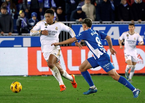 Jude Bellingham (kiri) saat Deportivo Alaves vs Real Madrid dalam laga lanjutan Liga Spanyol 2023/24 di Stadion Mendizorroza pada Jumat (22/12) dini hari WIB. Foto: Reuters/Vincent West