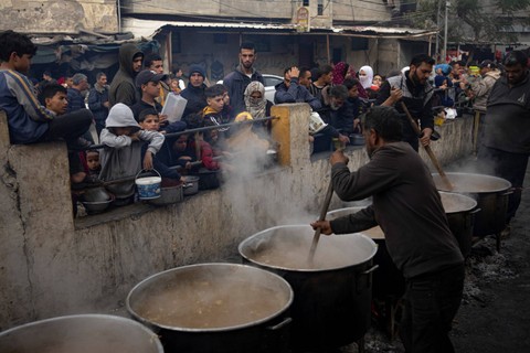 Warga Palestina mengantri untuk mendapatkan makanan gratis di Rafah, Jalur Gaza, Kamis (21/12/2023). Foto: Fatima Shbair/AP Photo