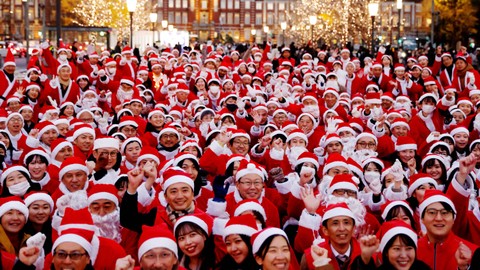 Peserta yang mengenakan pakaian Sinterklas berpose untuk foto sebelum acara  membagikan hadiah dan membersihkan jalan untuk merayakan musim Natal mendatang di Tokyo, Jepang 22 Desember 2023. Foto: REUTERS/Kim Kyung-Hoon