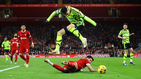 Pemain Liverpool Dominik Szoboszlai  berebut bola dengan pemain Arsenal Gabriel Martinelli pada pertandingan Liga Inggris di Anfield, Liverpool, Inggris, Minggu (24/12/2023). Foto: Carl Recine/REUTERS