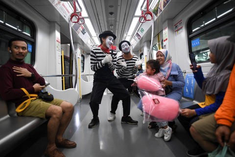 Seniman pantomim berinteraksi dengan penumpang di gerbong kereta Light Rail Transit (LRT) di Stasiun Velodrome, Jakarta, Senin (25/12/2023). Foto: M Risyal Hidayat/Antara Foto 