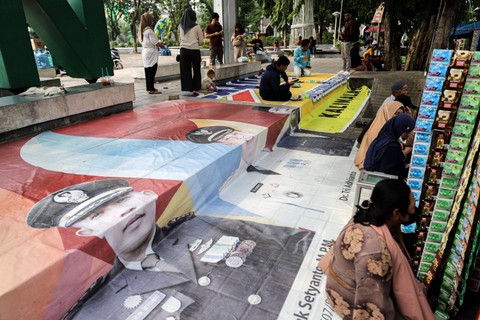 Dijadikan alas tempat duduk: Sejumlah warga duduk di atas alat peraga kampanye (APK) yang sudah tidak terpakai di Bekasi, Jawa Barat. Foto: Iqbal Firdaus/kumparan