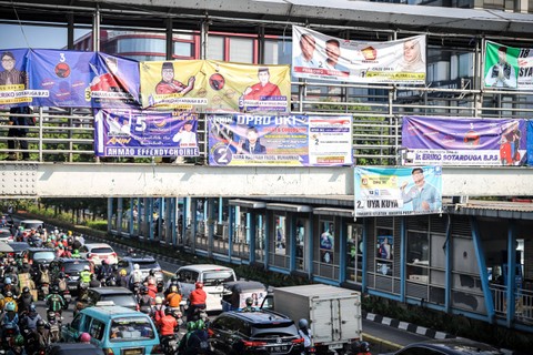 Alat peraga kampanye (APK) Pemilu 2024 terpasang di jembatan penyeberangan orang (JPO) di Salemba, Jakarta Pusat. Foto: Iqbal Firdaus/kumparan