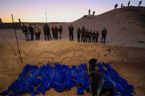 Mayat warga Palestina yang terbunuh di Gaza utara, dimakamkan di kuburan massal di Rafah, di Jalur Gaza selatan, Selasa (26/12/2023). Foto: Mahmud Hams/AFP